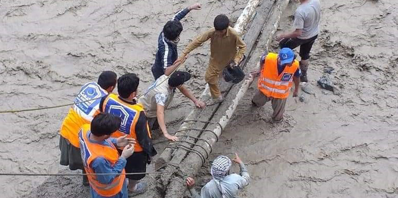 Reshun village locals and volunteers build a makeshift bridge 